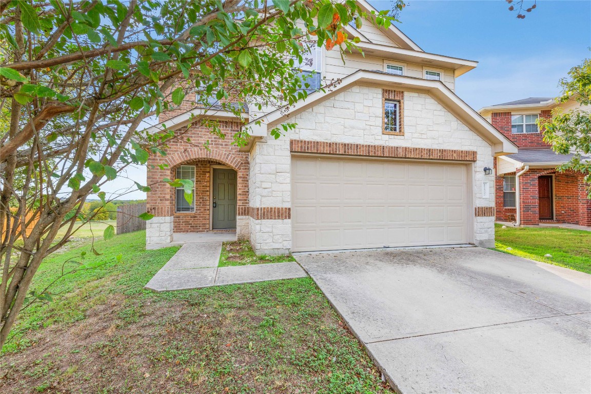 a front view of a house with a yard and garage