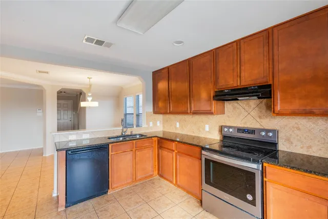 a kitchen with granite countertop stainless steel appliances and wooden cabinets