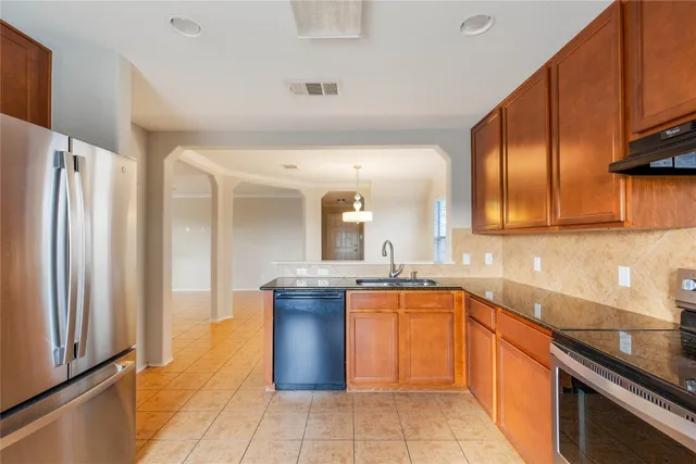 a kitchen with stainless steel appliances granite countertop a sink stove and refrigerator