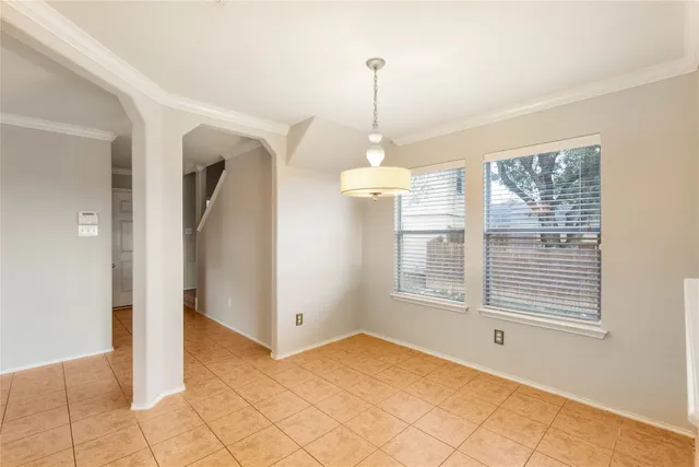 a view of empty room with window and chandelier
