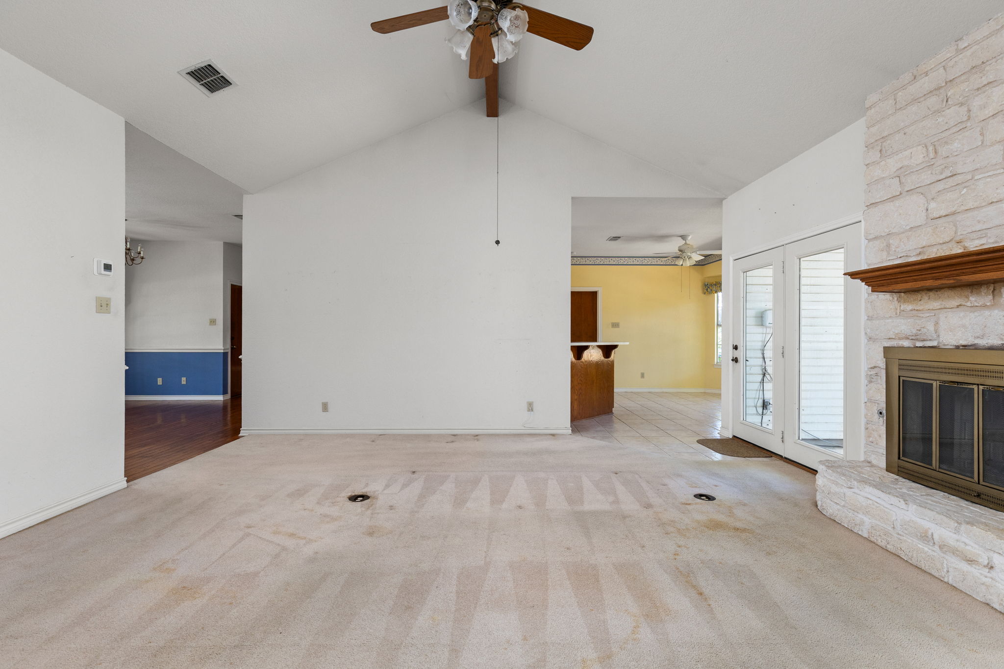 134 Canyon Road Georgetown, TX 78628 - Photo 7 of 40 Vaulted ceilings and a stone fireplace create a welcoming focal point in this living area.