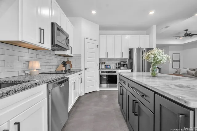 a kitchen with stainless steel appliances granite countertop a sink stove and cabinets
