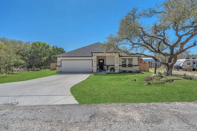 a front view of a house with a garden and yard