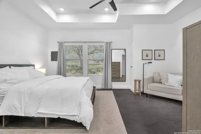 a spacious bedroom with a bed couch and a window