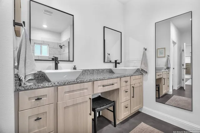 a spacious bathroom with a granite countertop sink and a mirror