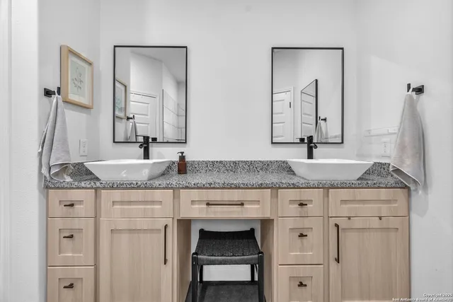 a bathroom with a granite countertop sink and a mirror