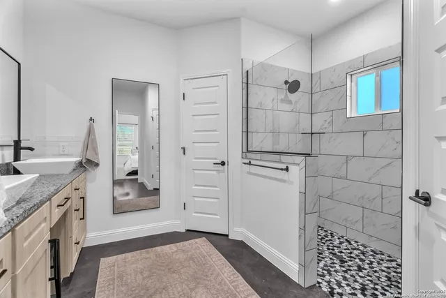 a bathroom with a granite countertop sink a toilet and shower