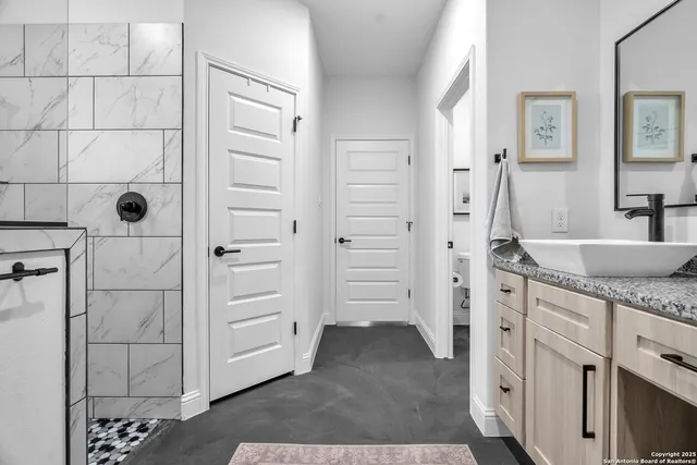 a bathroom with a granite countertop sink a vanity and a shower
