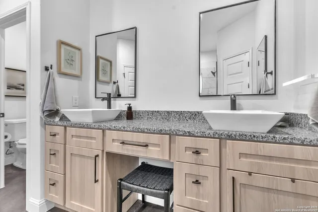 a bathroom with granite countertop a sink and a mirror