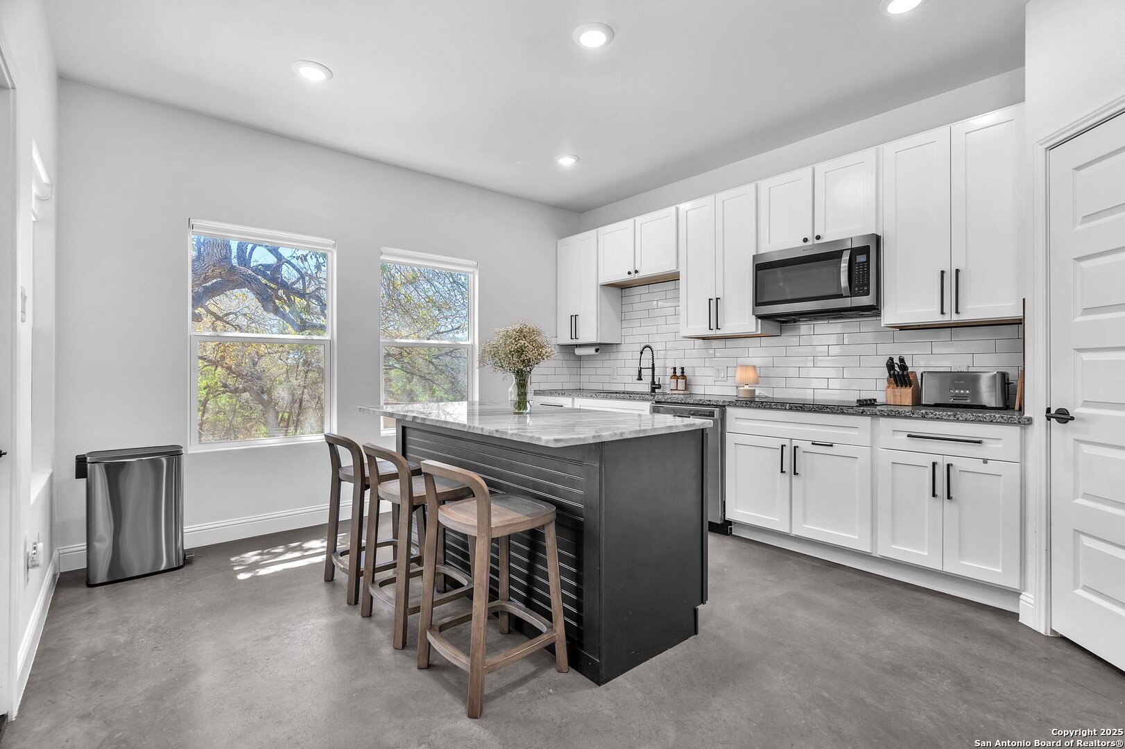 348 Fawn Drive Spring Branch, TX 78070 - Photo 35 of 50 a kitchen with stainless steel appliances granite countertop a stove a sink a microwave a refrigerator a dining table and chairs