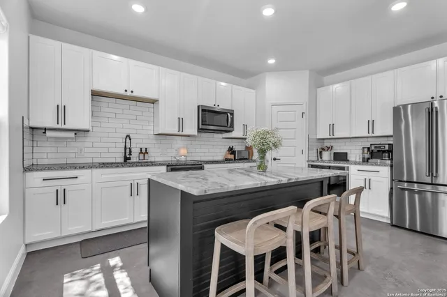 a kitchen with refrigerator cabinets dining table and chairs