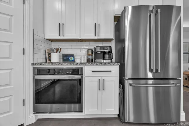 a kitchen with stainless steel appliances granite countertop a refrigerator stove and sink