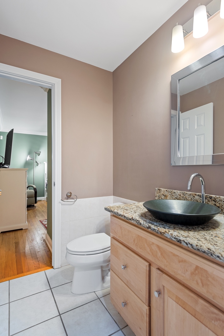 463 Green Bay Road Highland Park, IL 60035 - Photo 13 of 27 a bathroom with a granite countertop sink a toilet and mirror
