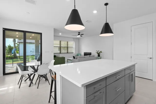 a kitchen with stainless steel appliances a stove a sink a microwave a center island and cabinets