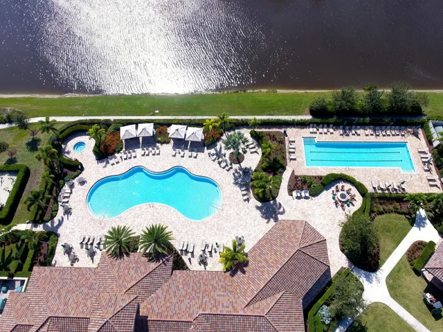 a view of swimming pool with seating space and trees in the background