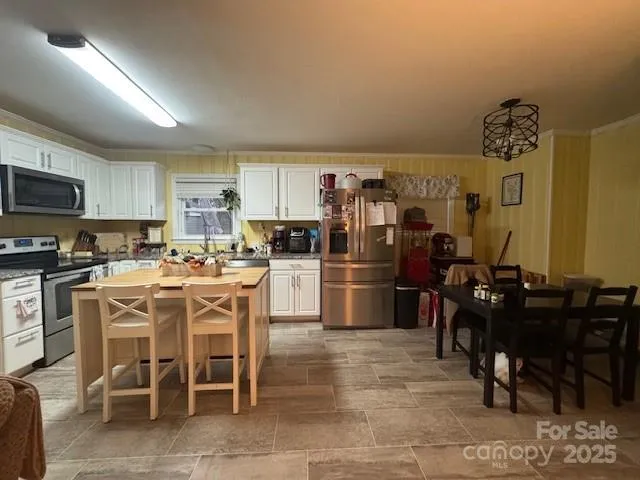 a kitchen with a refrigerator a table and chairs in it