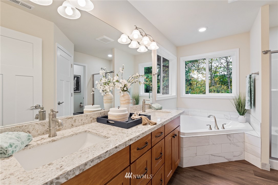 17839 Southeast 128th Street Renton, WA 98059 - Photo 14 of 35 a bathroom with a granite countertop sink a large mirror and a bathtub with window
