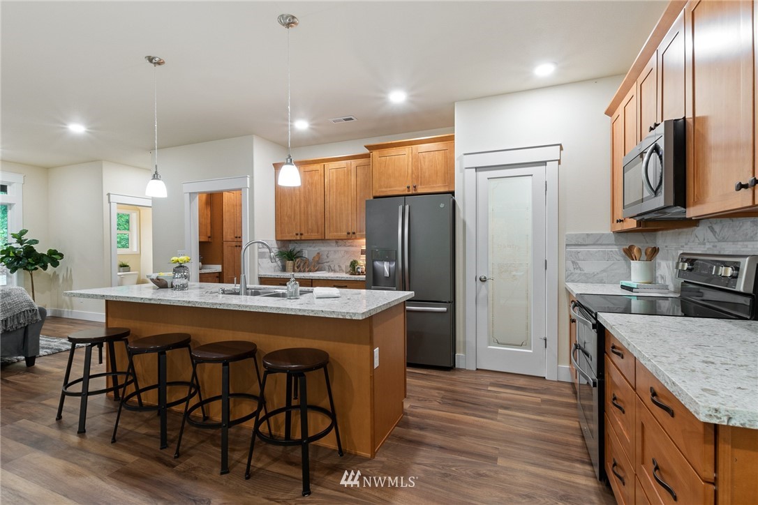 17839 Southeast 128th Street Renton, WA 98059 - Photo 6 of 35 a kitchen with stainless steel appliances granite countertop a table chairs a refrigerator and a sink