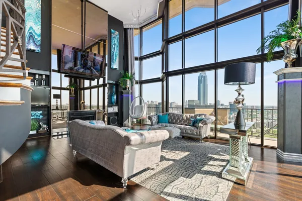 a living room with furniture fireplace and floor to ceiling windows
