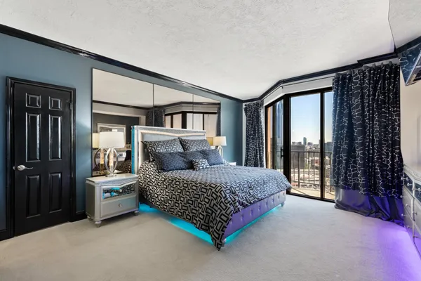 a bedroom with a bed and a view of living room