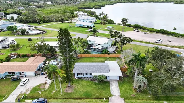 an aerial view of residential houses with outdoor space and river