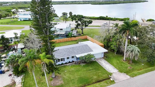an aerial view of a house with garden space and a lake view