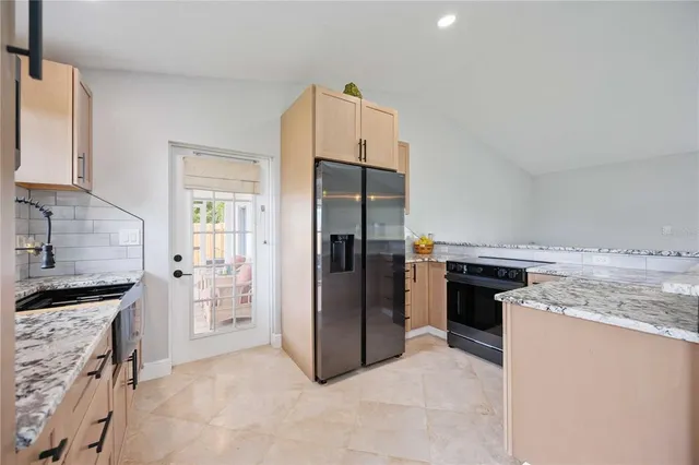a kitchen with a stove top oven and refrigerator