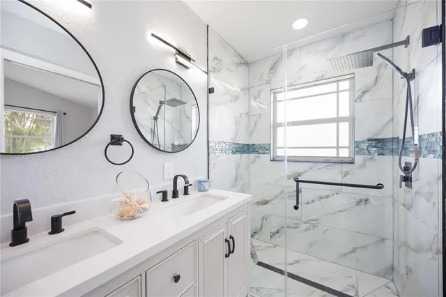 a bathroom with a double vanity sink mirror and window