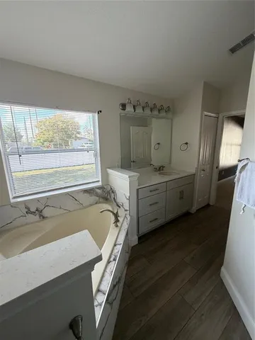 a spacious bathroom with a double vanity sink a mirror and a bathtub