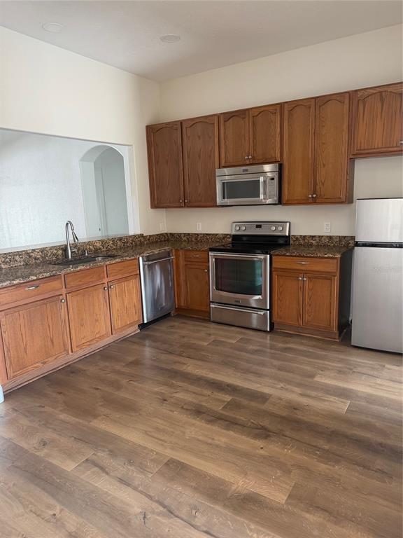 3020 Norlina Street Deltona, FL 32738 - Photo 9 of 30 a kitchen with granite countertop a stove a sink and a microwave