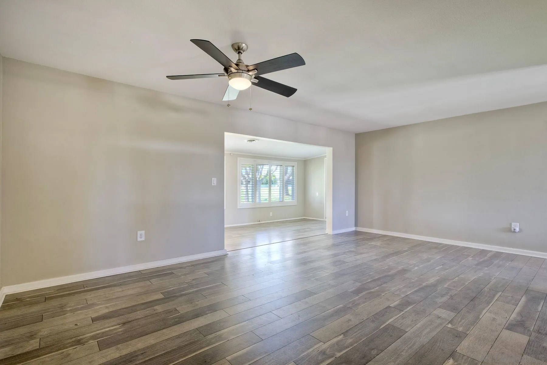 26055 Cherry Hills Boulevard Menifee, CA 92586 - Photo 16 of 31 a view of an empty room with wooden floor and a window