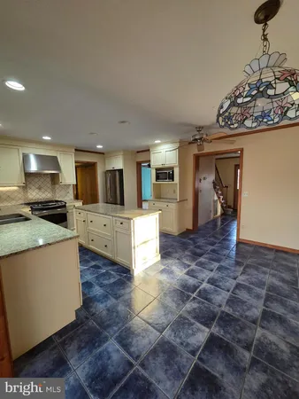 a large kitchen with stainless steel appliances granite countertop a stove and a refrigerator