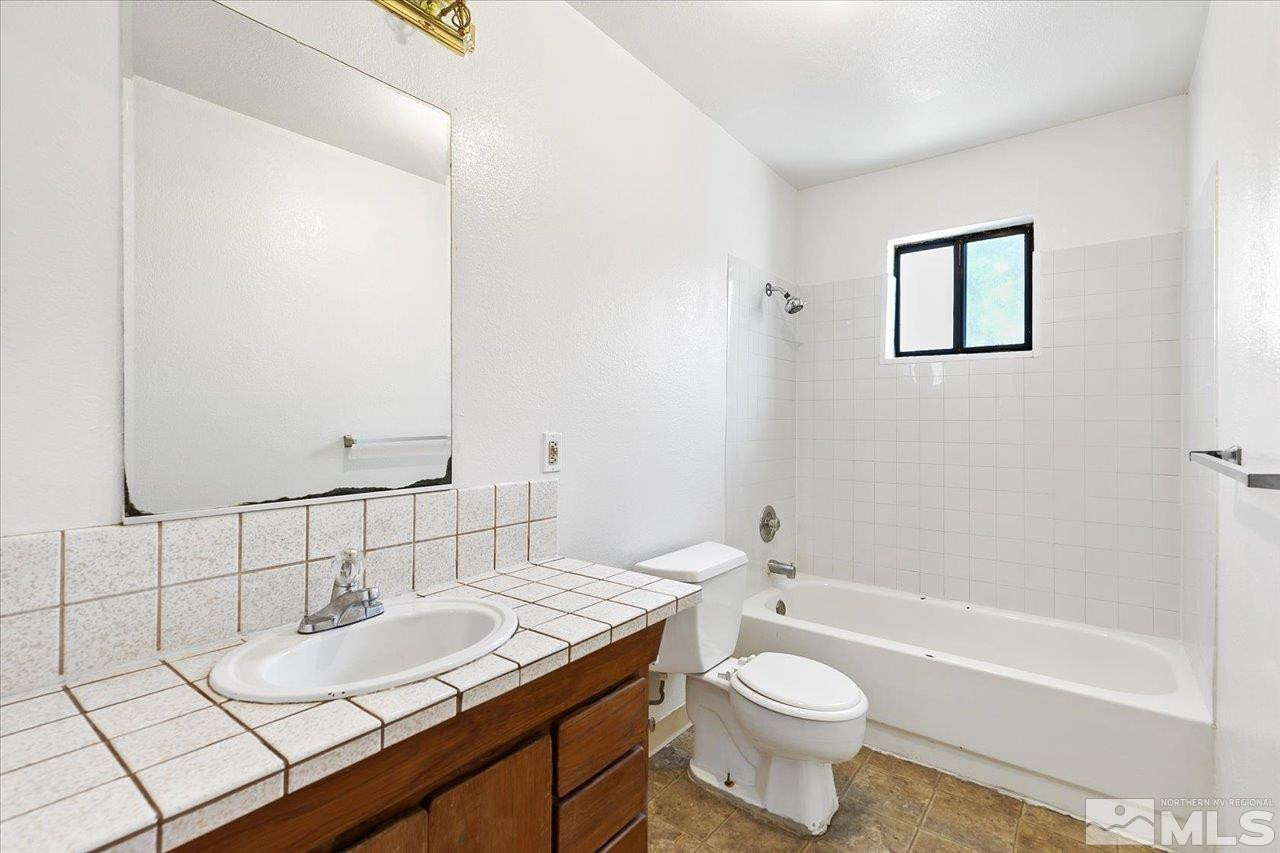 364 Wheeler Avenue Reno, NV 89502 - Photo 11 of 11 a bathroom with a granite countertop sink toilet and shower