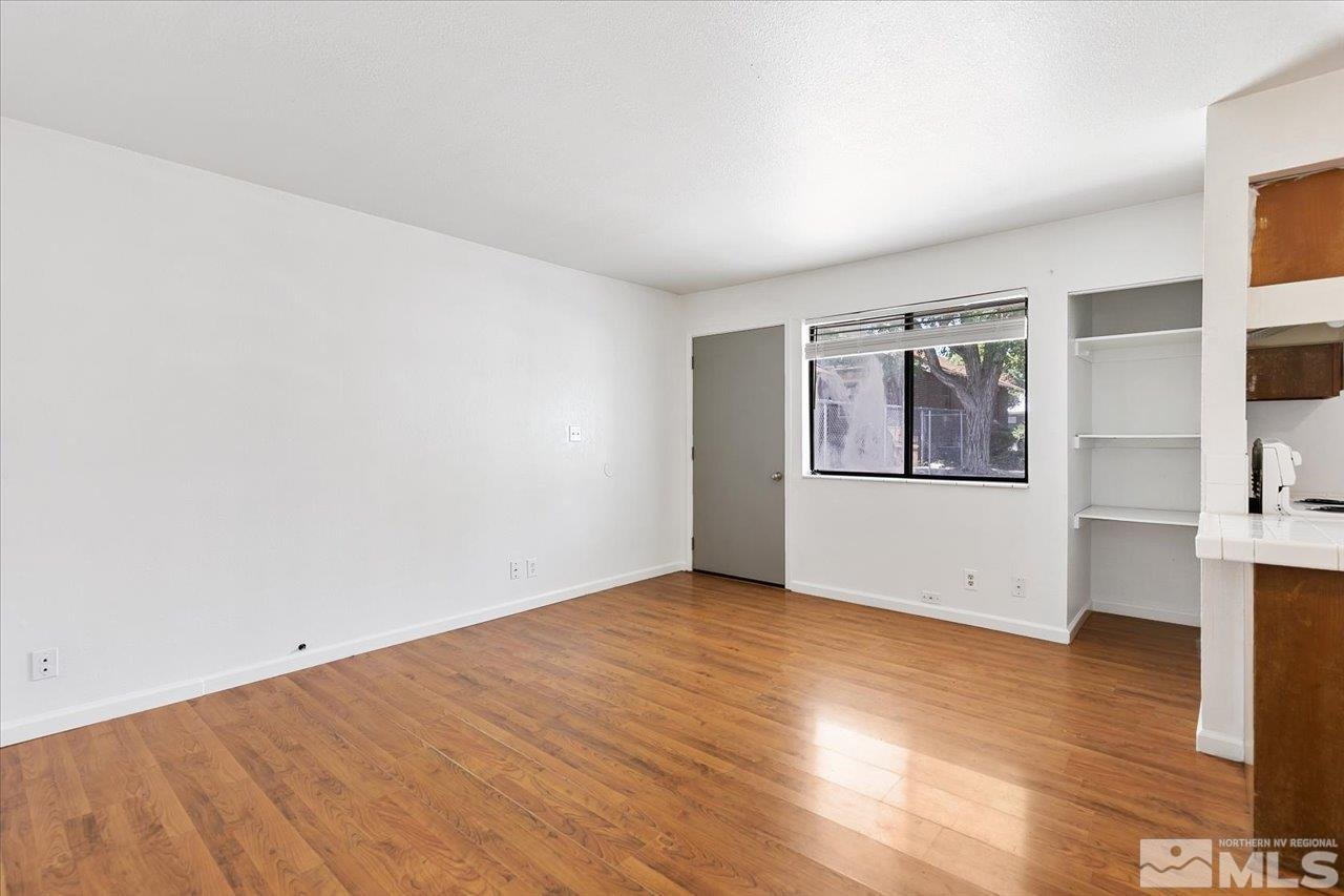 364 Wheeler Avenue Reno, NV 89502 - Photo 4 of 11 an empty room with wooden floor and windows