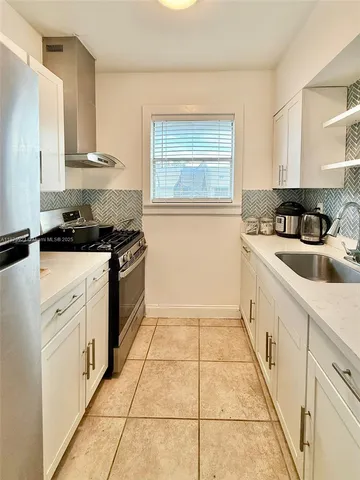 a kitchen with a stove a sink and a refrigerator