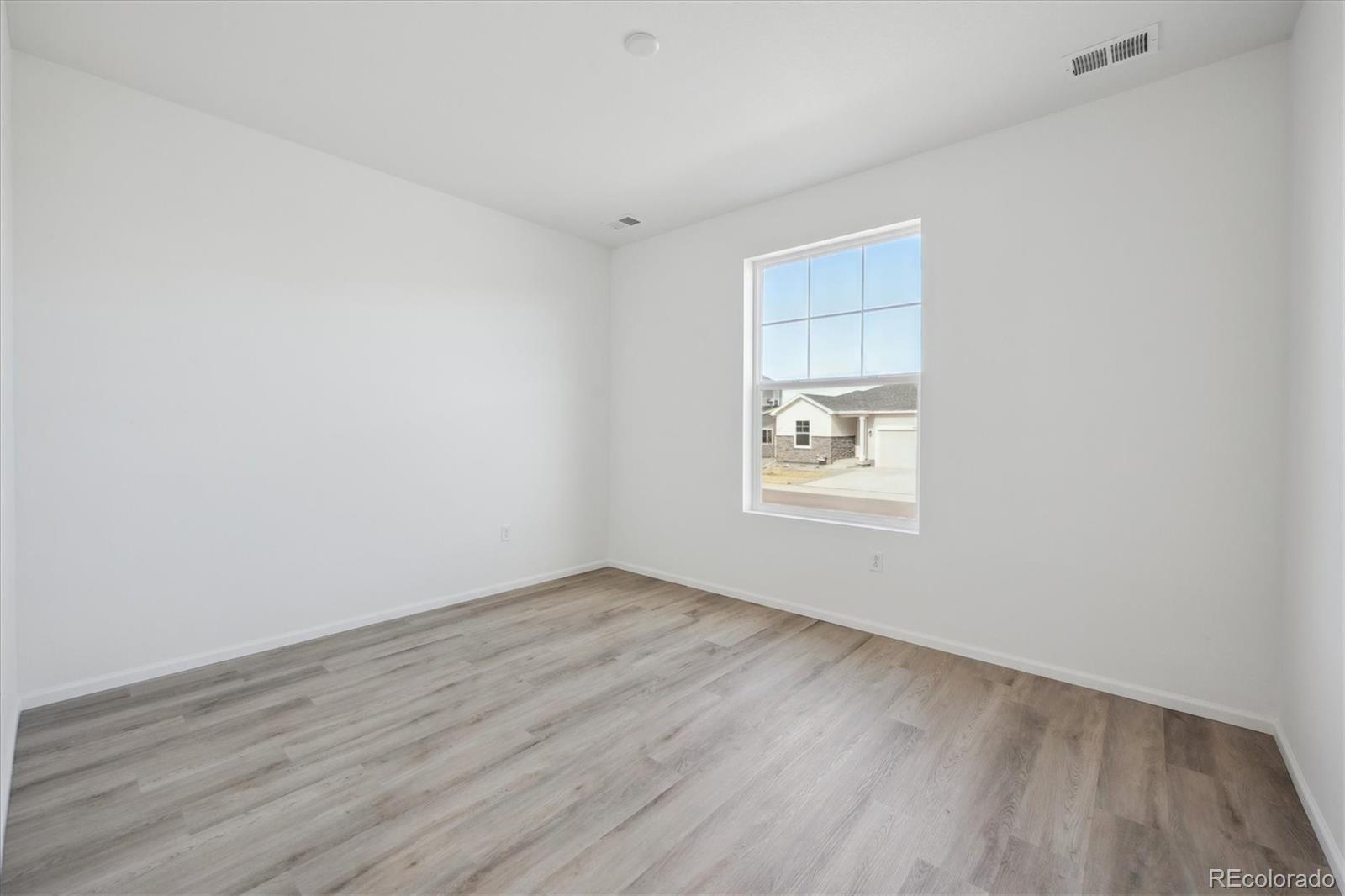 6122 Amerifax Drive Windsor, CO 80528 - Photo 2 of 21 an empty room with wooden floor and windows