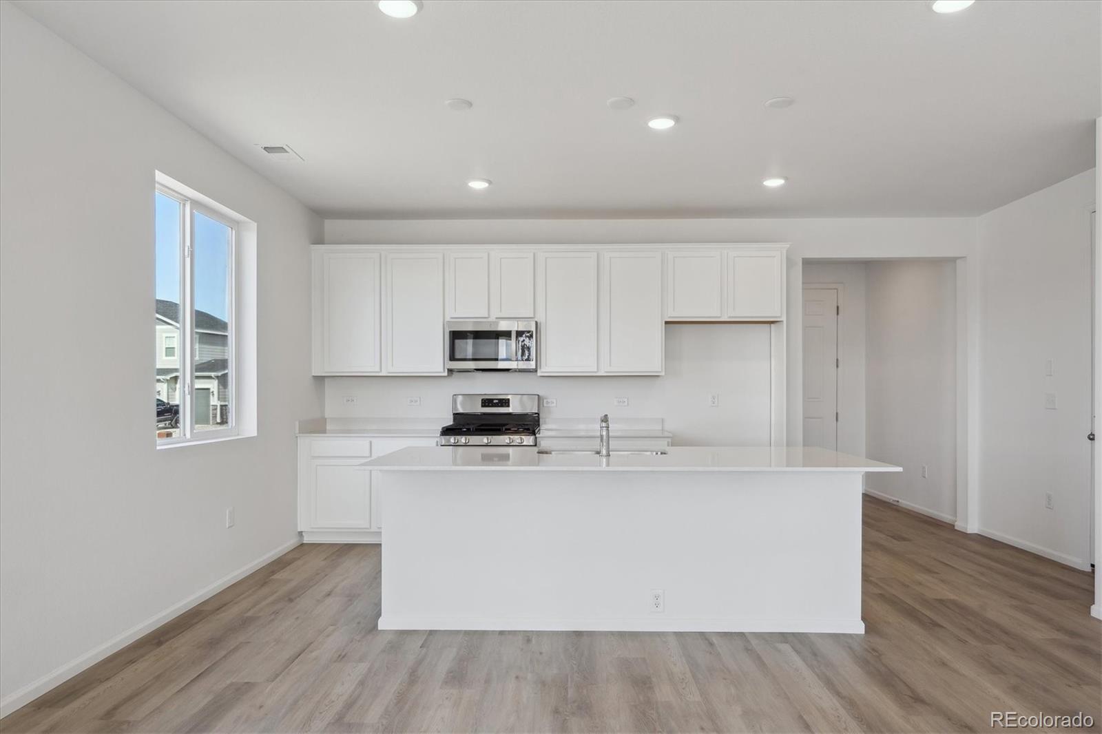 6122 Amerifax Drive Windsor, CO 80528 - Photo 3 of 21 a view of a kitchen with center island and stainless steel appliances