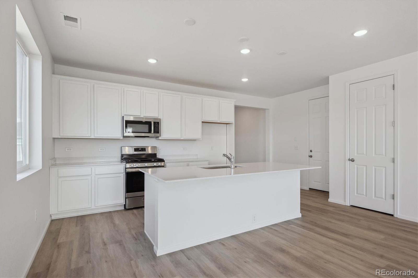 6122 Amerifax Drive Windsor, CO 80528 - Photo 4 of 21 a kitchen with stainless steel appliances a sink a stove a refrigerator and cabinets