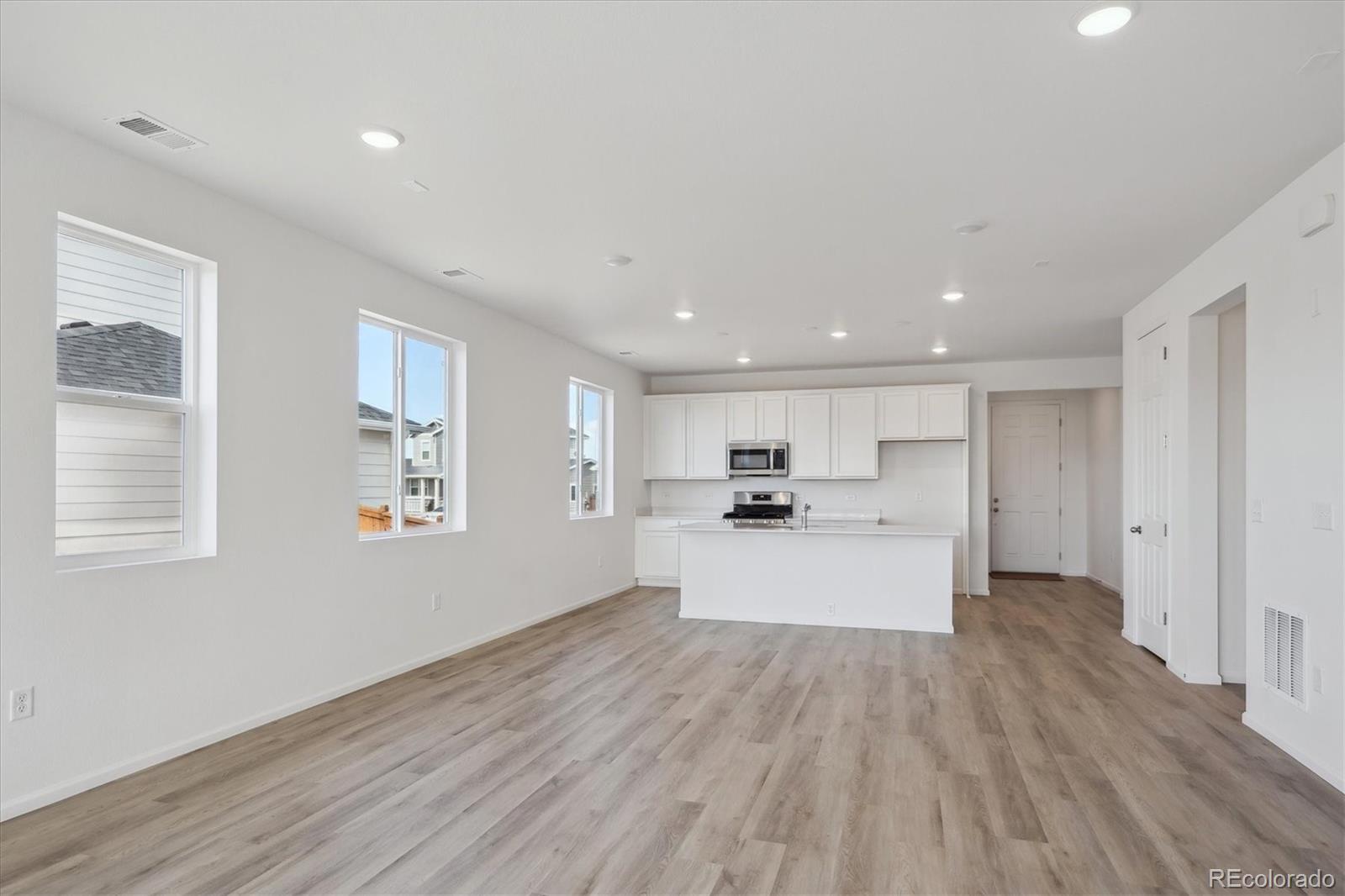 6122 Amerifax Drive Windsor, CO 80528 - Photo 10 of 21 a view of kitchen with kitchen island stainless steel appliances wooden floor window and wooden floor