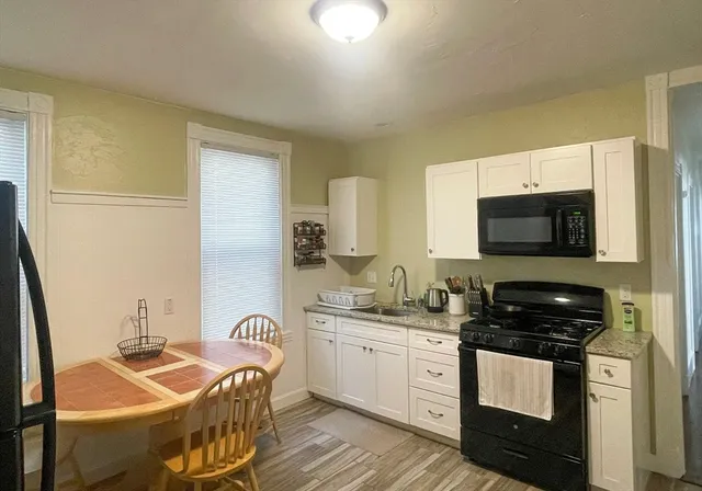 a kitchen with stainless steel appliances kitchen island granite countertop a sink and a stove top oven