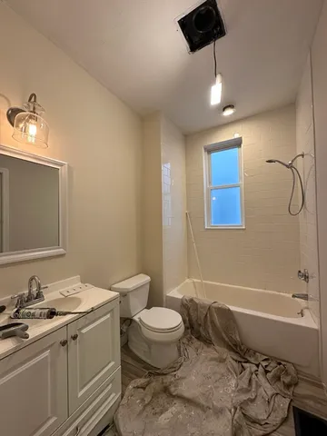 a bathroom with a granite countertop sink a toilet and shower