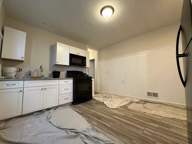 a kitchen with a refrigerator and a stove top oven