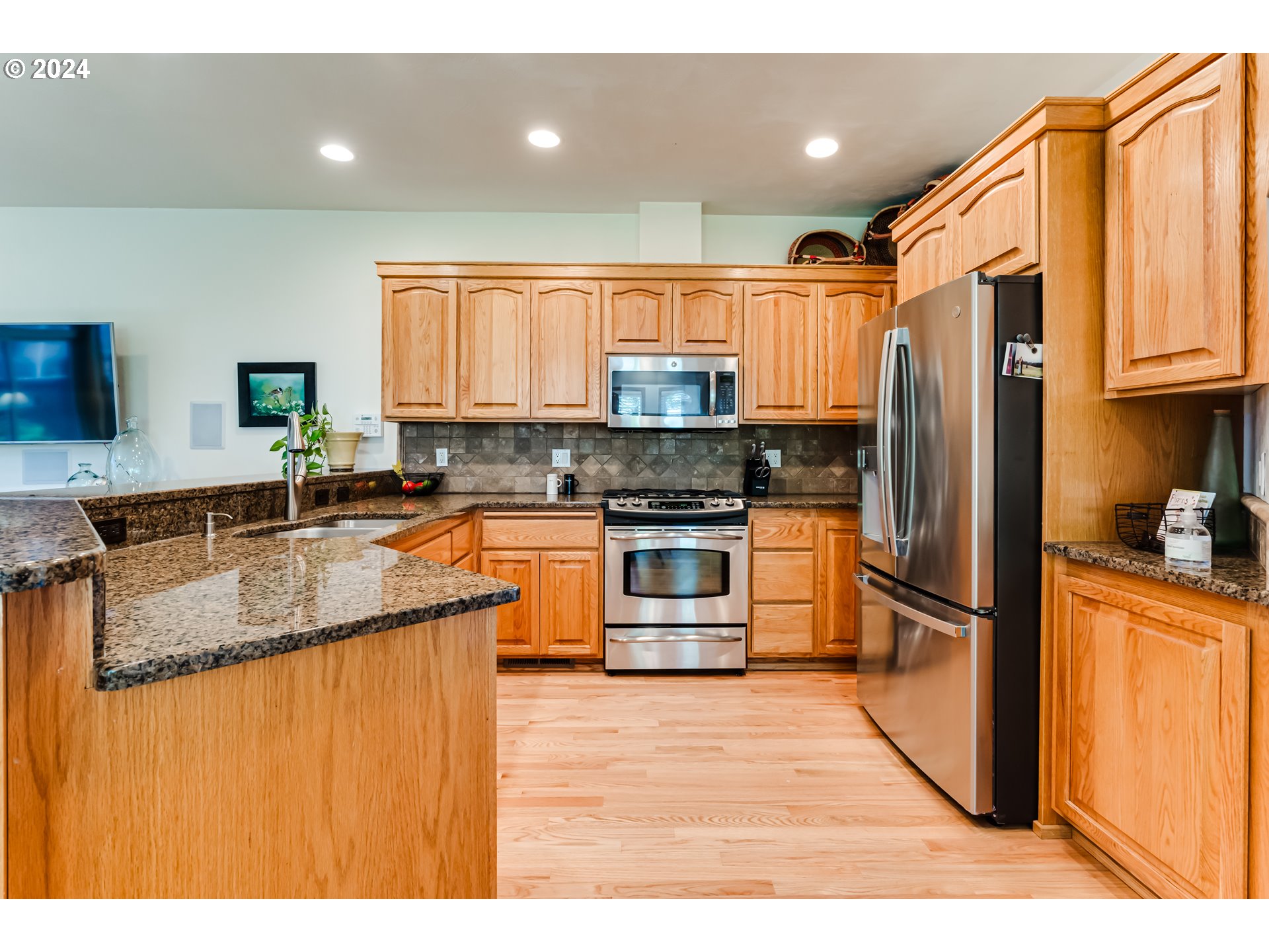 999 Old Orchard Lane Springfield, OR 97477 - Photo 6 of 34 a kitchen with stainless steel appliances granite countertop a refrigerator a sink dishwasher a stove with wooden cabinets
