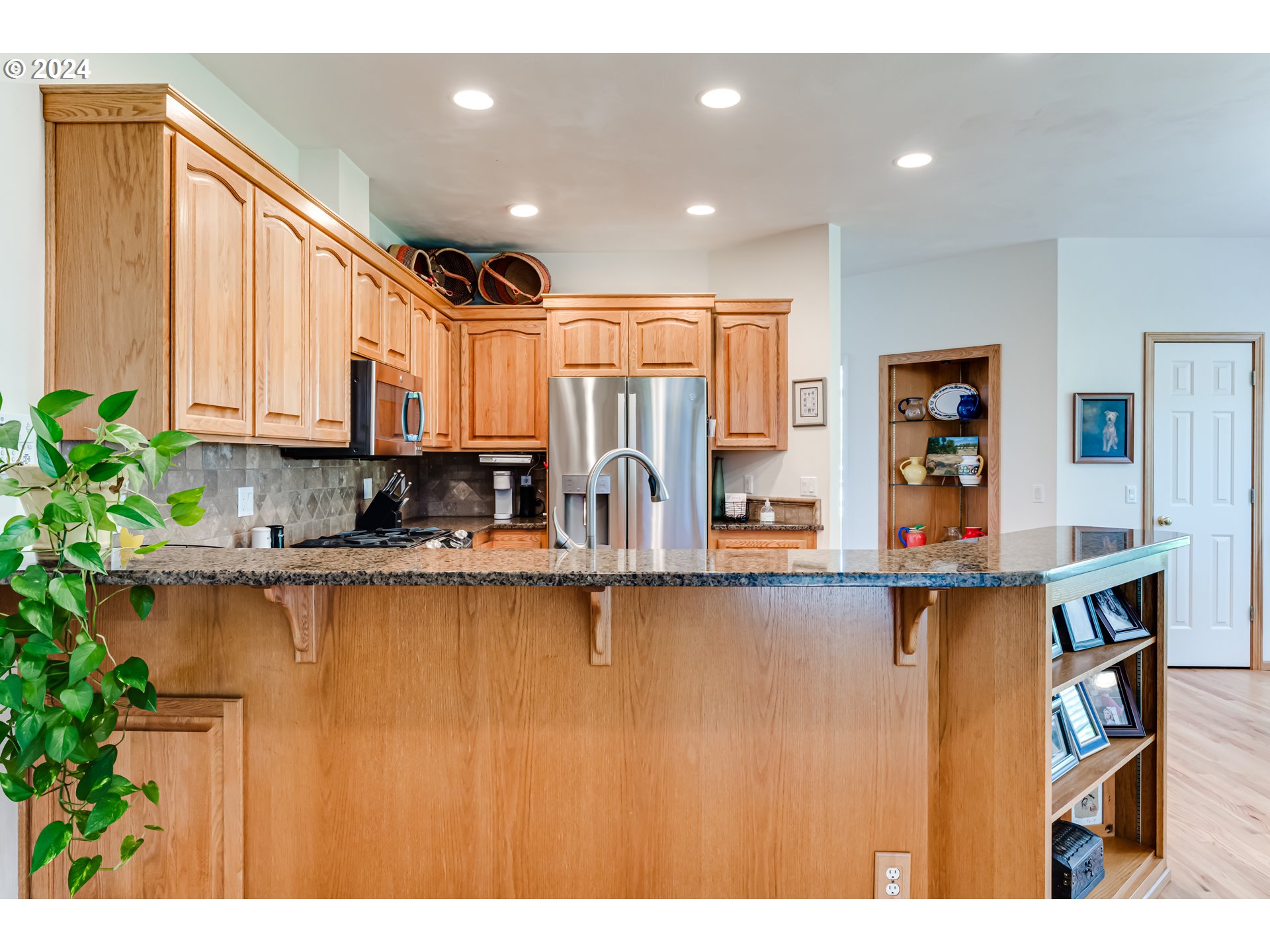 999 Old Orchard Lane Springfield, OR 97477 - Photo 8 of 34 a kitchen with stainless steel appliances granite countertop a refrigerator a stove and a sink with wooden cabinets