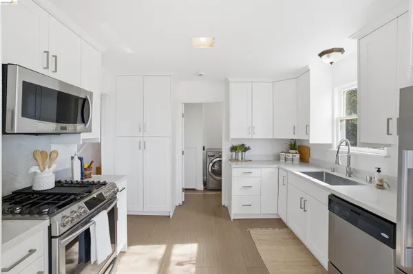 a kitchen with white cabinets and appliances