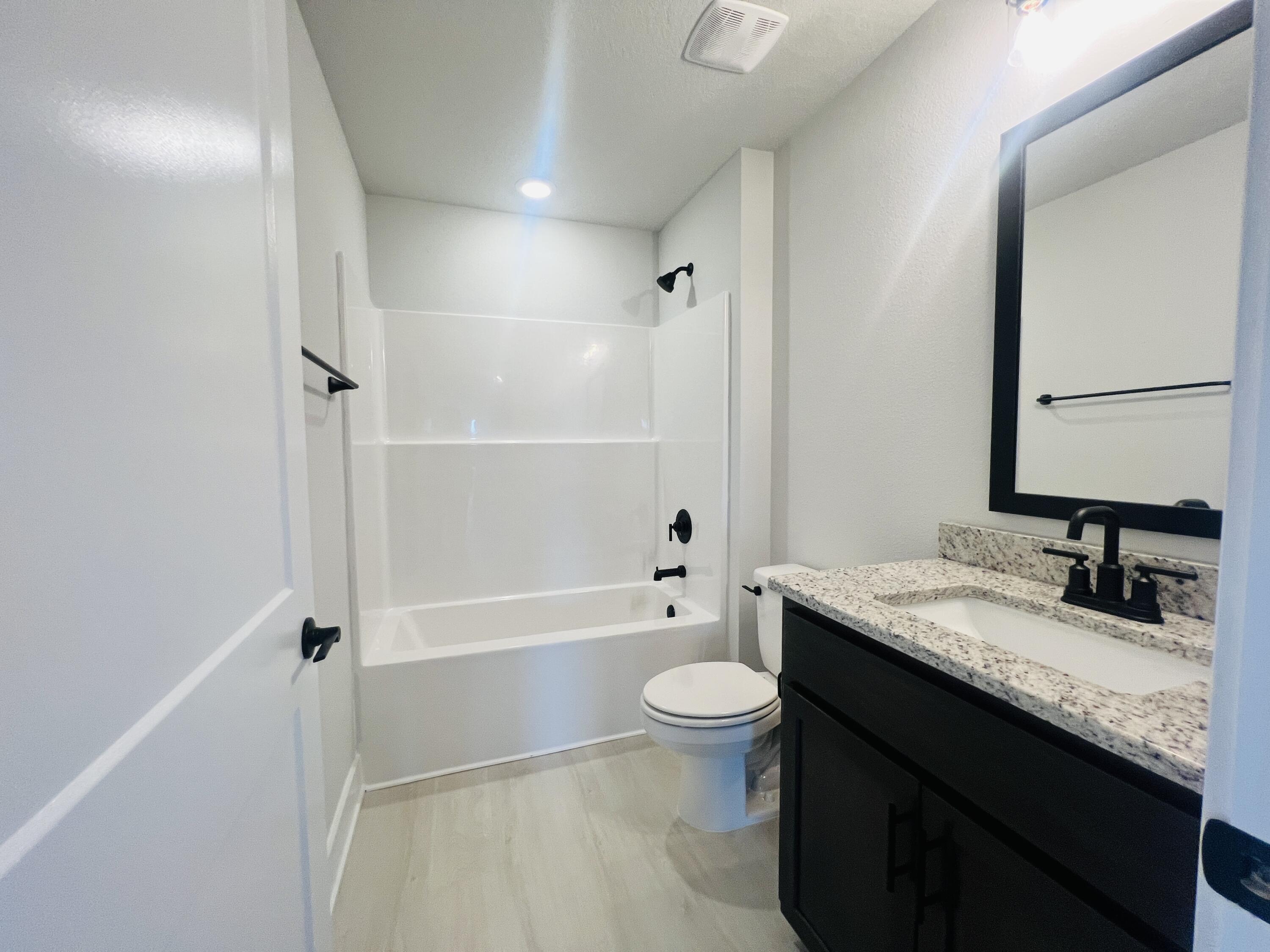 5291 Hidden Pines Circle Milton, FL 32583 - Photo 15 of 21 a bathroom with a granite countertop sink toilet mirror and bathtub