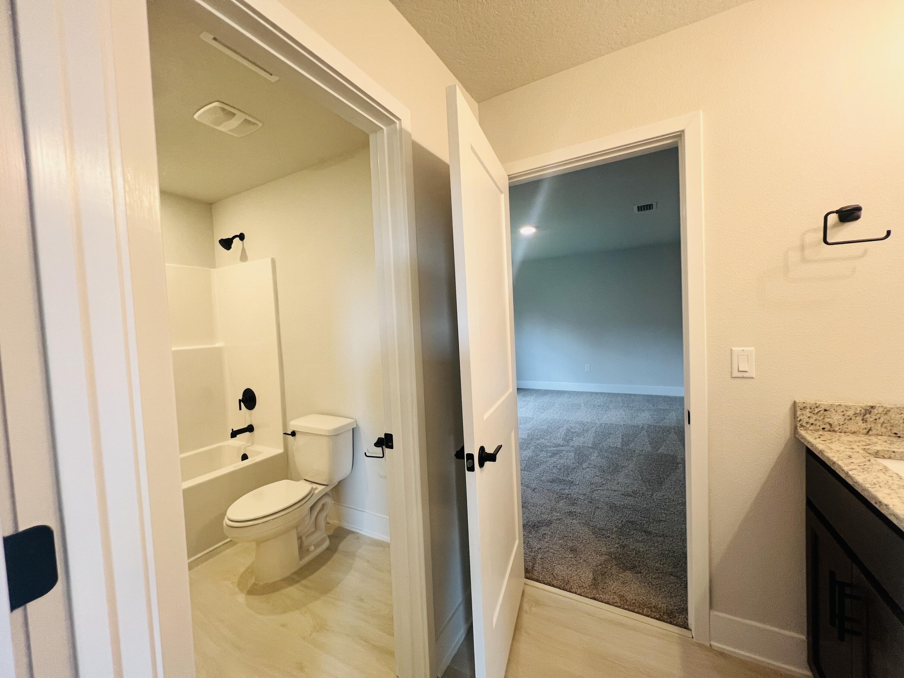 5291 Hidden Pines Circle Milton, FL 32583 - Photo 19 of 21 a bathroom with a granite countertop sink a toilet and shower