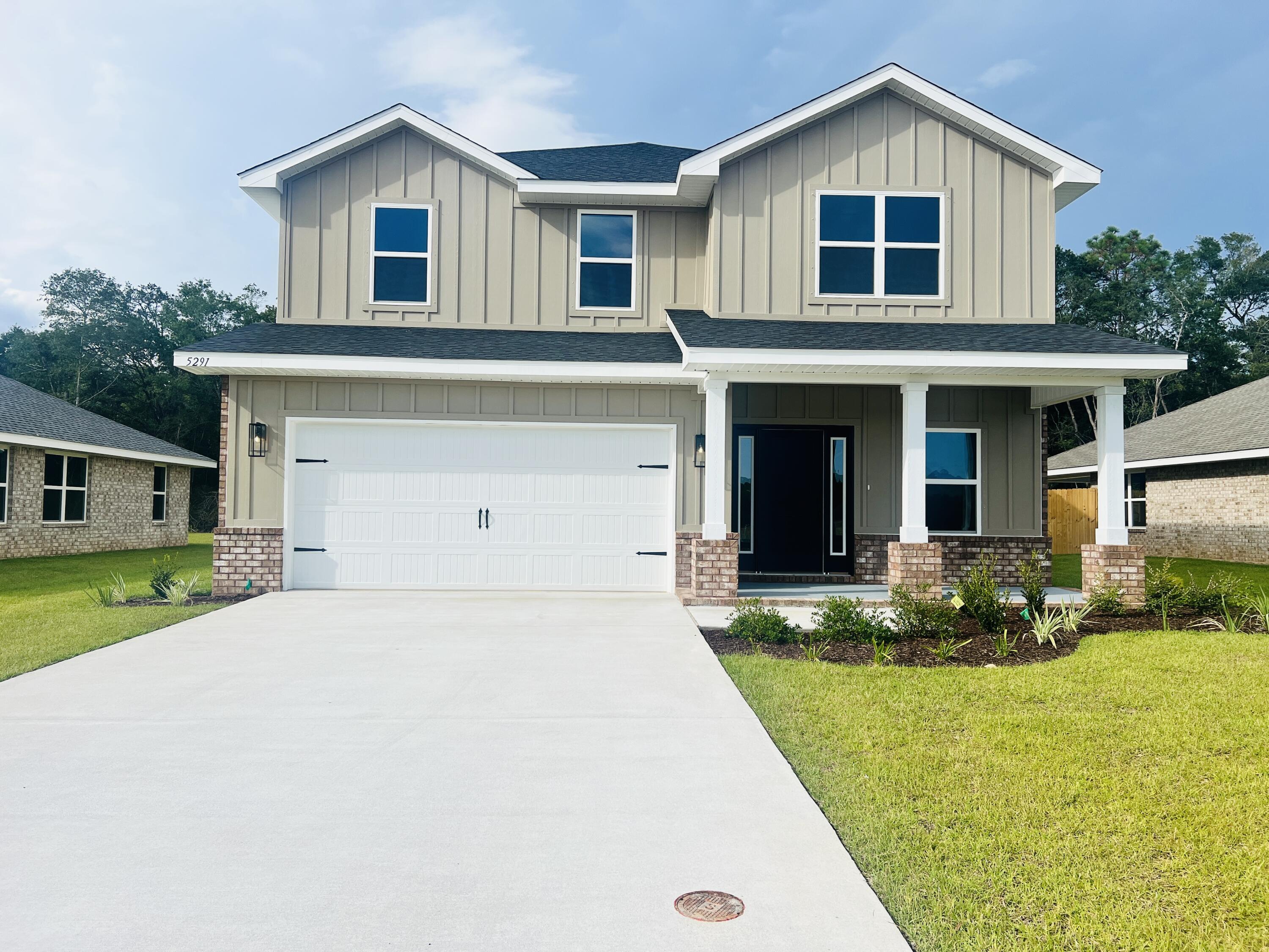 5291 Hidden Pines Circle Milton, FL 32583 - Photo 3 of 21 a front view of a house with a yard and garage