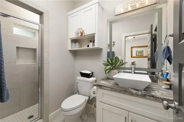 a bathroom with a granite countertop sink mirror vanity and toilet