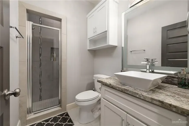 a bathroom with a granite countertop sink a toilet and shower